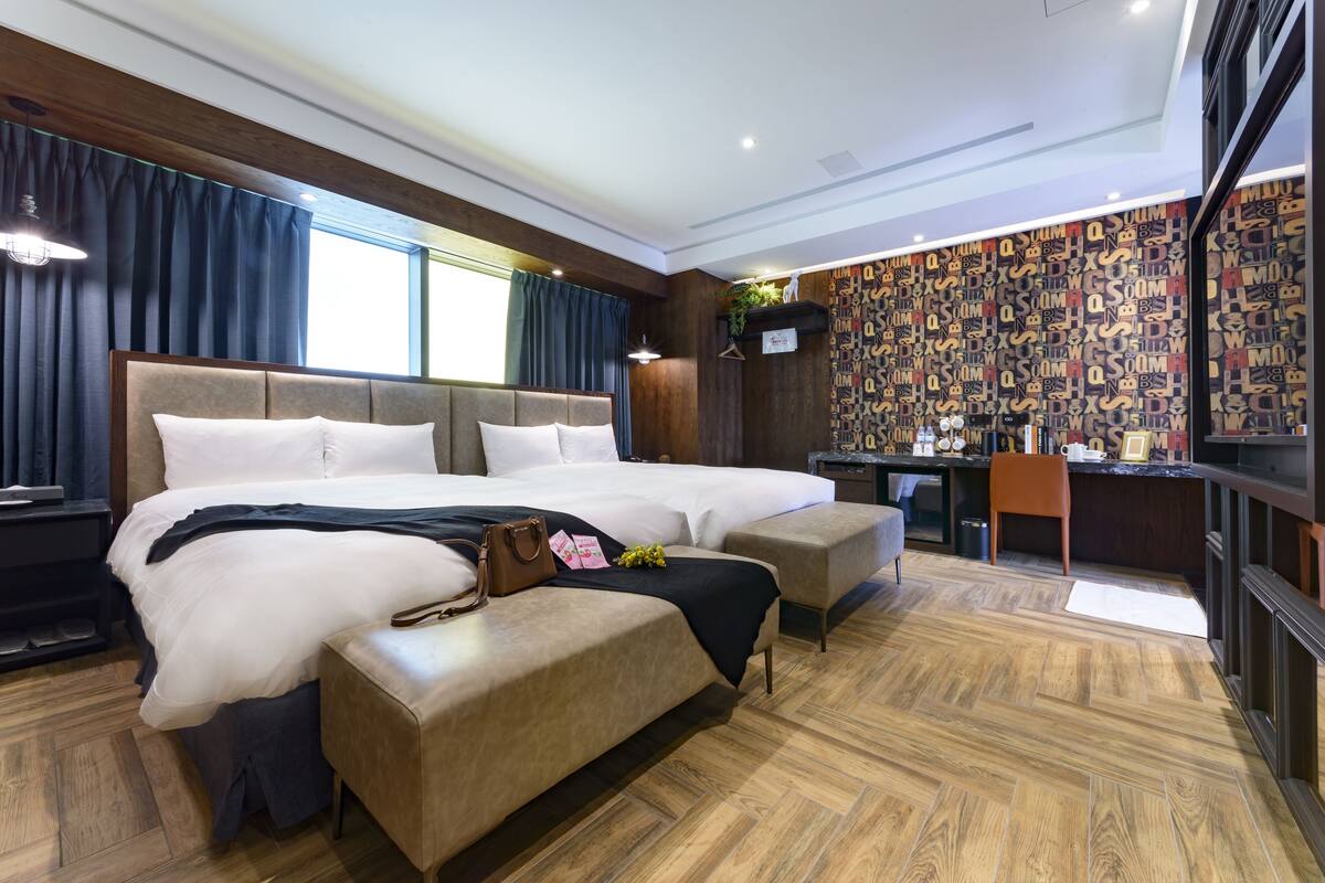 Una habitación de hotel moderna con una cama grande, un escritorio y vistas a la ciudad.