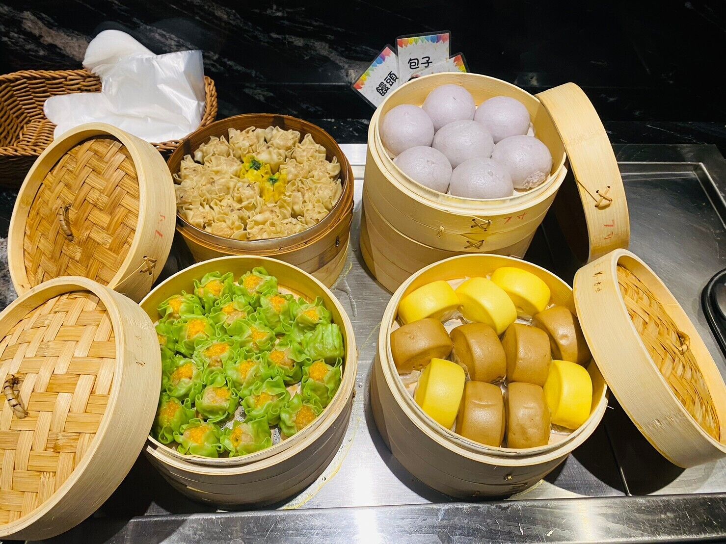 A variety of food items in bamboo steamers, including dumplings, noodles, and other dishes.