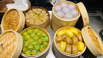 A variety of food items in bamboo steamers, including dumplings, noodles, and other dishes.