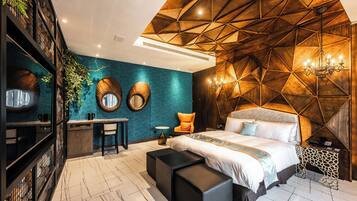 A modern bedroom with a geometric wooden ceiling, a large bed, a desk, and a chair.