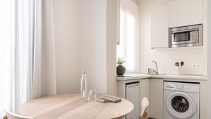 Una cocina moderna equipada con microondas, lavavajillas y lavadora.