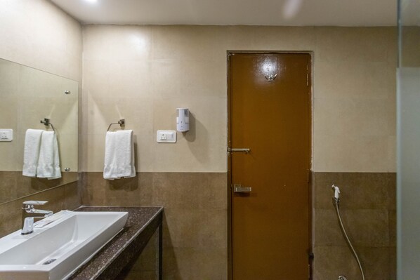 A bathroom with a sink, mirror, towel rack, and shower.