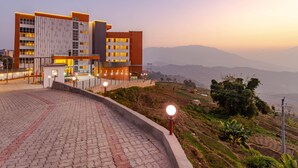 A hotel with a modern design, featuring a prominent entrance and a view of the surrounding landscape.