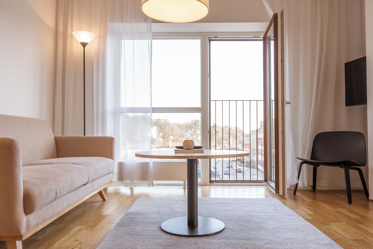 A modern living room with a sofa, a round table, and a chair.
