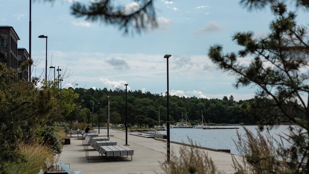 A waterfront walkway with benches and street lamps. - Story Living Lidingö (Lidingo)