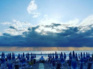 A beach with rows of umbrellas and chairs, a clear sky, and the ocean in the background. - Sunny Escape near Silver Beach for 3 (Alba Adriatica (TE))
