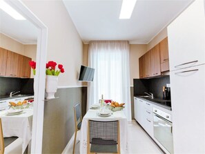 Jääkaappi, uuni, liesi, ruokailupöytä