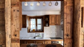 Una cocina rústica con armarios de madera, un ventanal grande y un fregadero.