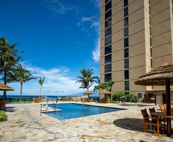 Relax by the oceanfront pool surrounded by lounge chairs and umbrellas.