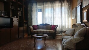 Ein Wohnzimmer mit einer Couch, einem Couchtisch und einem Fernseher.