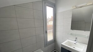 A modern bathroom with a bathtub, a sink, and a large mirror.