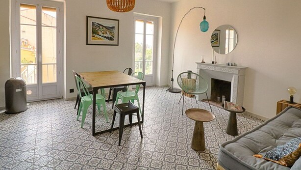 A living room with a fireplace, a dining area with a table and chairs, and a sofa. - Ajaccio: Charming 2BR, 4 guests, Wifi, Downtown (Ajaccio)