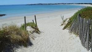A sandy beach path leading to the ocean with a wooden fence on one side and vegetation on the other. - House 300 metres from the beach (LOCTUDY)