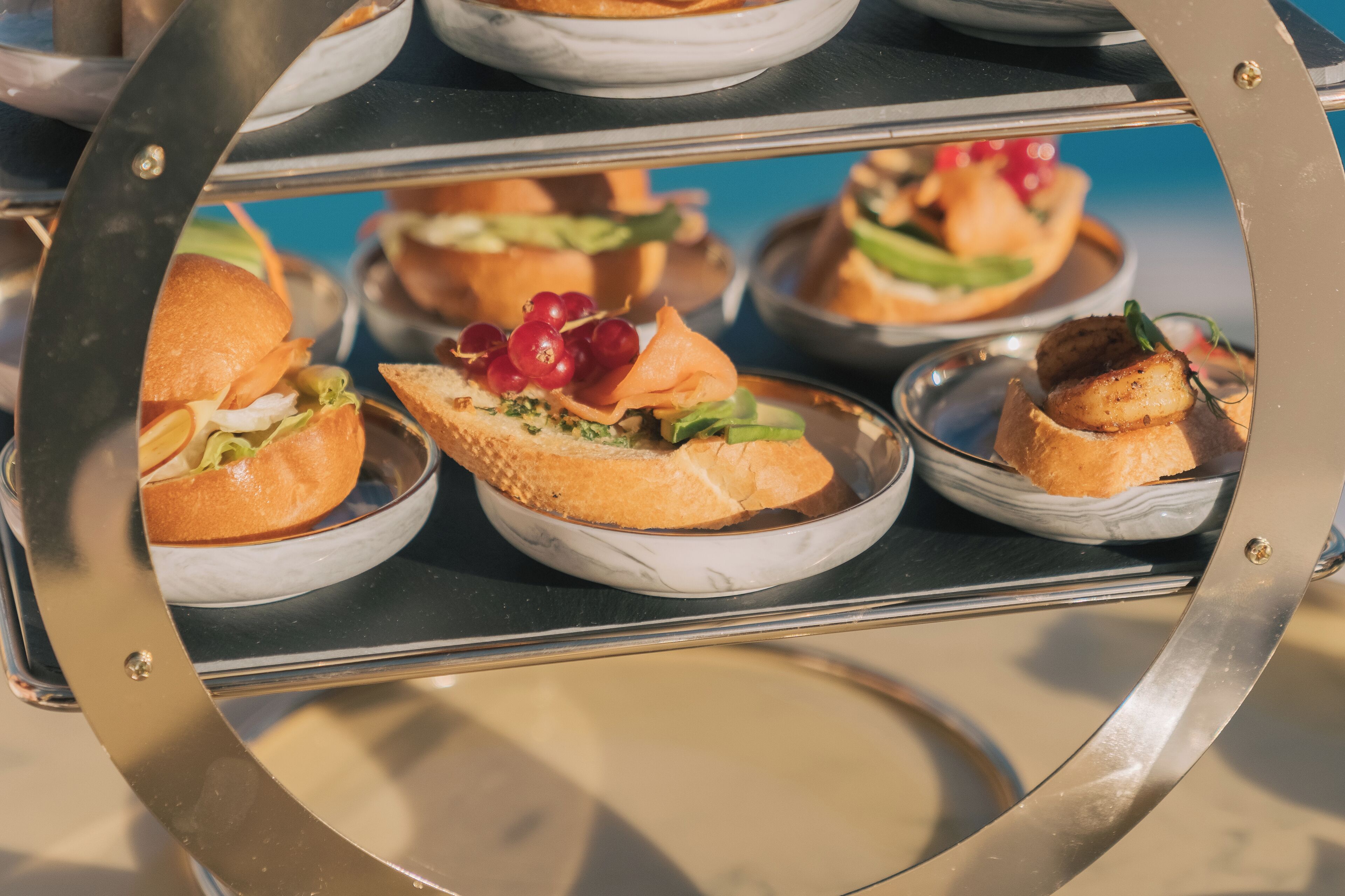 Un bufé con diversos platos, incluyendo sándwiches, ensaladas y mariscos.