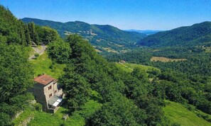 A rural landscape with a stone building, surrounded by lush greenery and rolling hills. - Tuscan House in the Green (Toscana)