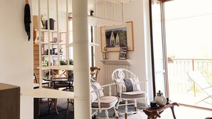 Een ruime woonkamer met een hoge plafond, een trap en een balkon.