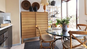Een moderne keuken met een eetgedeelte, houten kastjes en een glazen tafel.
