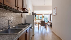 A kitchen with granite countertops, stainless steel appliances, and wooden cabinets. - Pet-Friendly Apartment "Casa Museddu" with A/C, Terraces & Garden (Cardedu)