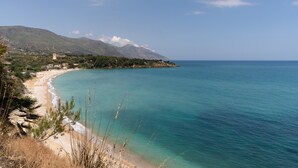 A coastal landscape with a beach, clear blue sea, and a mountain in the background. - Apartment 'Casa Rossa' with Sea View, Veranda & Wi-Fi (Castellammare del Golfio)