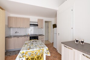 Une cuisine de taille réduite comprenant une table à manger, des chaises et un réfrigérateur.