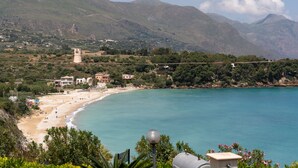 A coastal landscape with a beach, a tower, and a bridge.
