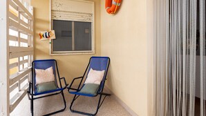 Two blue lounge chairs with cushions, a white railing, a window with a life preserver on the wall, and a curtain. - Apartment 'Mare & Relax' near the sea with terrace and Wi-Fi (Menfi)