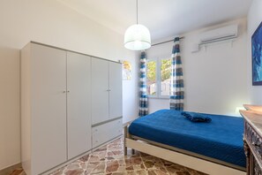 Un dormitorio con cama, armario y aire acondicionado.
