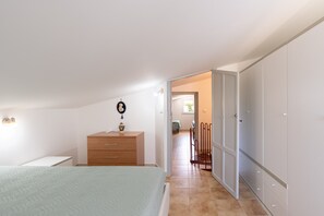 A bedroom with a bed, a dresser, a wardrobe, and a chair. - Apartment 'Casa Verde' with Sea View, Terrace & Wi-Fi (Castellammare del Golfio)
