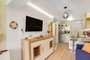 A modern kitchen with a TV, wooden cabinets, and a bar area.