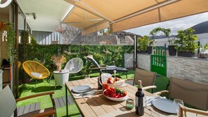 A patio with a table set for dining, outdoor seating, and a view of a lake. - Apartment 'Esther Dream Bungallow' with Pool, Wi-Fi, A/C, Terrace & Garden (Mogán)