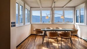A dining area with a wooden floor, a glass table, and six chairs. - Apartment 'Kraidlhof - Designapartment Isabel' with Mountain View, Shared Pool & Wi-Fi (Kurtatsch)