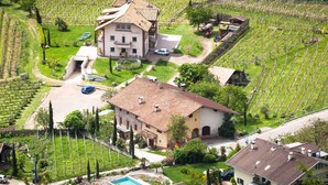 A large house with a swimming pool, surrounded by vineyard fields. - Apartment 'Kraidlhof - Designapartment Isabel' with Mountain View, Shared Pool & Wi-Fi (Kurtatsch)