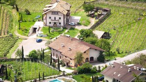 A large house with a swimming pool, surrounded by vineyards. - Apartment "Kraidlhof Designapartment Veronika" with Mountain View, Shared Pool and Wi-Fi (Kurtatsch)