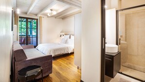 A bedroom with a bed, a sofa, a window, and a bathroom with a sink and shower. - Apartment "Kraidlhof Designapartment Veronika" with Mountain View, Shared Pool and Wi-Fi (Kurtatsch)