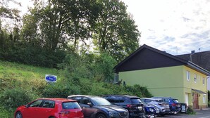 A row of parked cars along a roadside with a building in the background.