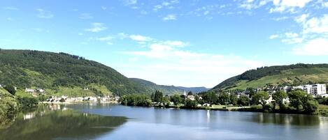 A calm lake with surrounding hills and a small town.