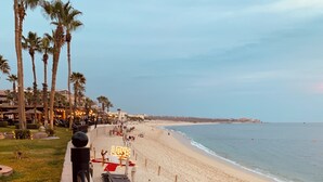 A beachside hotel with sun loungers and umbrellas, a 'LOVE' sign, and palm trees. - Villa La Estancia Unit # 2805 - B side Jr studio 2Q Beds Beach lux front resort. (Cabo San Lucas)