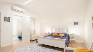 Een slaapkamer met een bed, nachtkastjes, een kledingkast en een airconditioning.