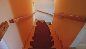 A wooden staircase with a handrail, leading to a landing.