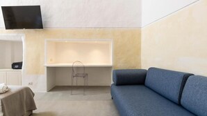 Ein modernes Wohnzimmer mit einem blauen Sofa, einem transparenten Sessel und einer eingebauten Badewanne.