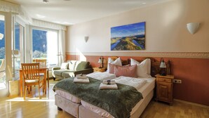 A bedroom with a large bed, a desk, and a chair.