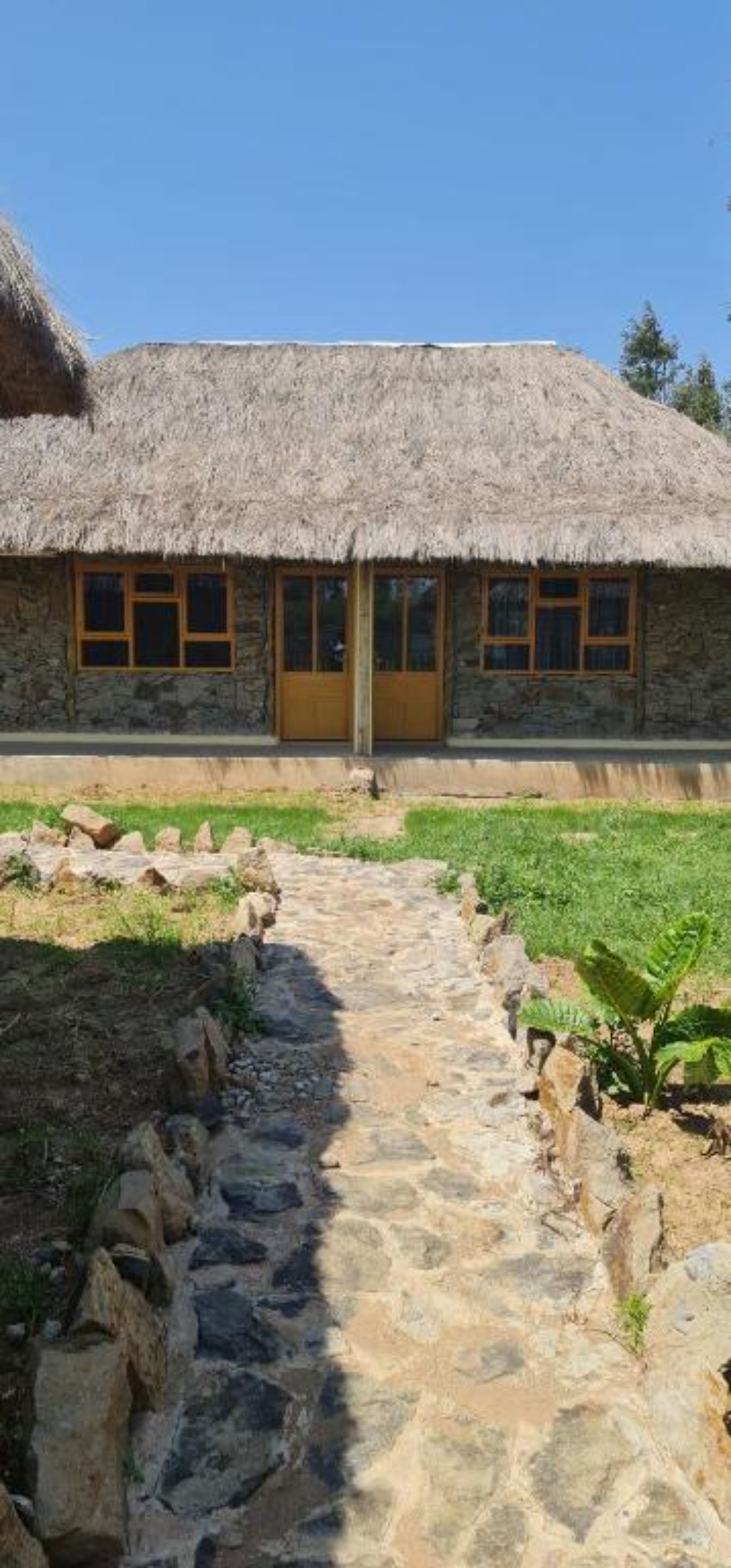 A stone building with a thatched roof and a wooden door.