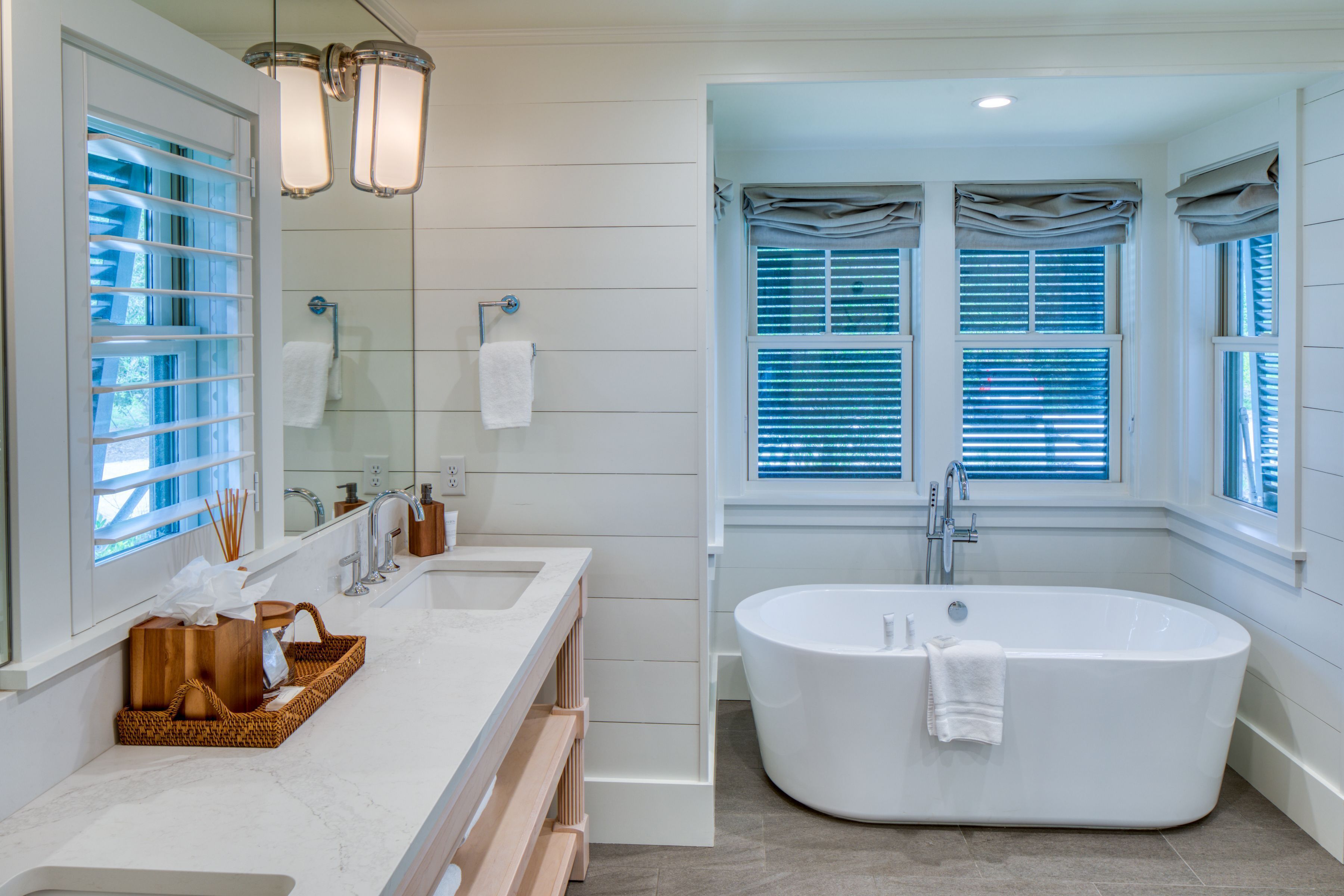 A modern bathroom with a freestanding bathtub, a double sink vanity, and a large mirror.