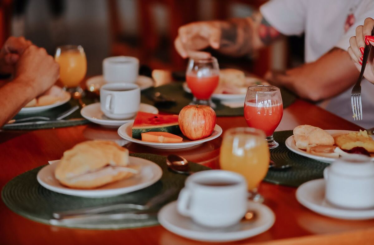 A breakfast setting with plates of food, drinks, and a casual dining atmosphere.