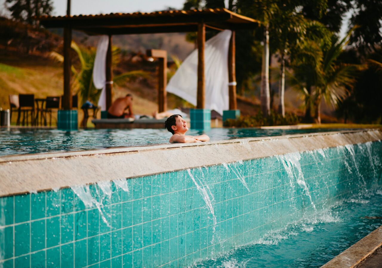 A swimming pool with a tiled edge and a person in the water.