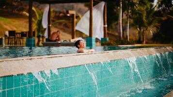 A swimming pool with a tiled edge and a person in the water.