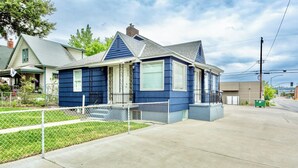 A two-story house with a blue exterior, a front porch, and a visible garage.