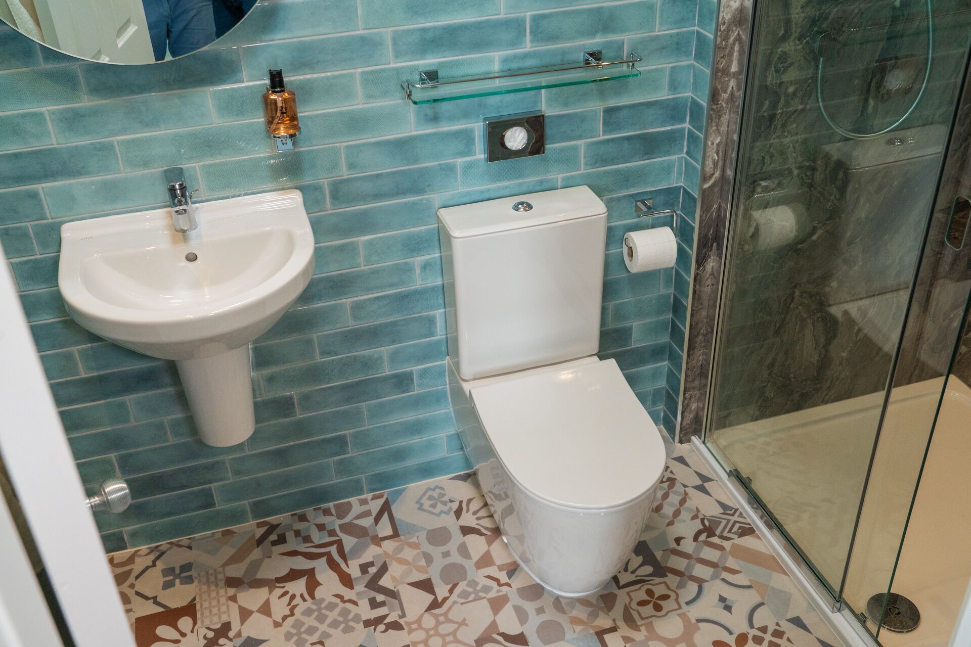 Un baño con lavamanos, inodoro y ducha blancos.