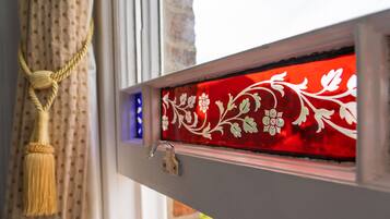 Una ventana con un panel de vidrio decorativo con motivos florales.