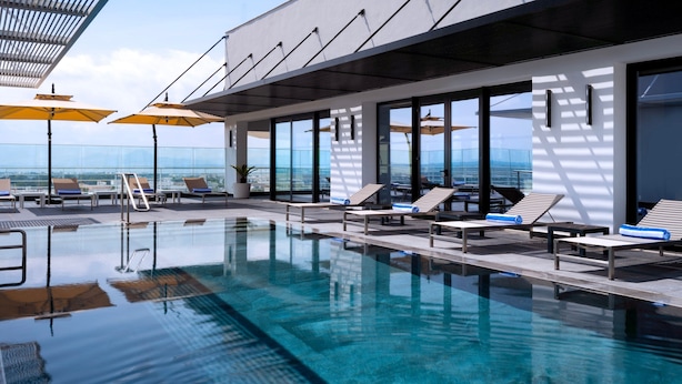 A modern indoor swimming pool with clear water, sun loungers, and umbrellas. - Tunis Marriott Hotel (Tunis)